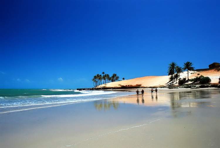 Foto da Praia de Paracuru com areias douradas e o mar calmo