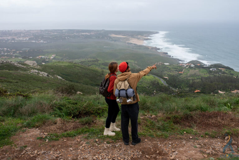 casal em cima montanha vendo o mar