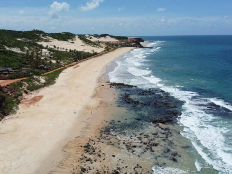 Vista panorâmica da Praia das Minas em Pipa com dunas e mar cristalino.