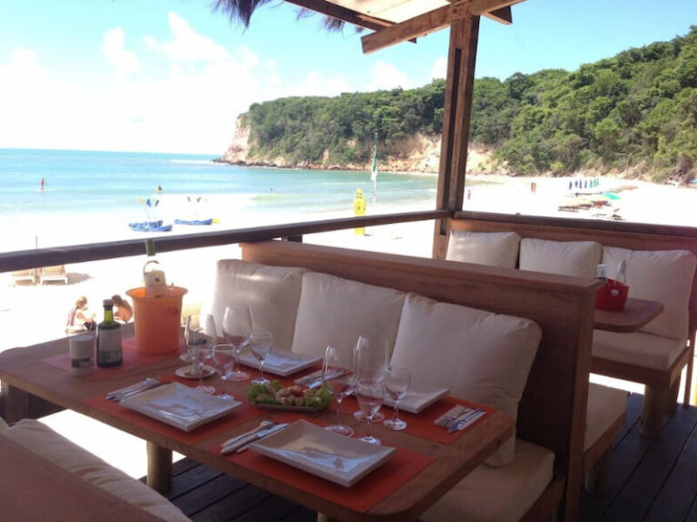 Mesa de restaurante em varanda com vista para o mar em Pipa.