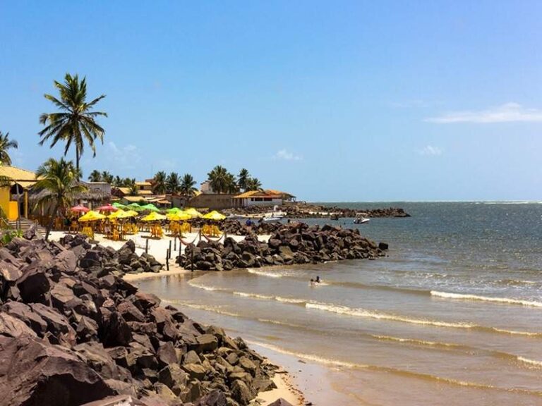 Praia do Saco com areia dourada, pedras e coqueiros, um paraíso sergipano