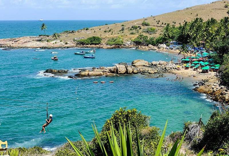Cenário idílico da Praia de Calhetas com suas águas azul-turquesa e natureza exuberante