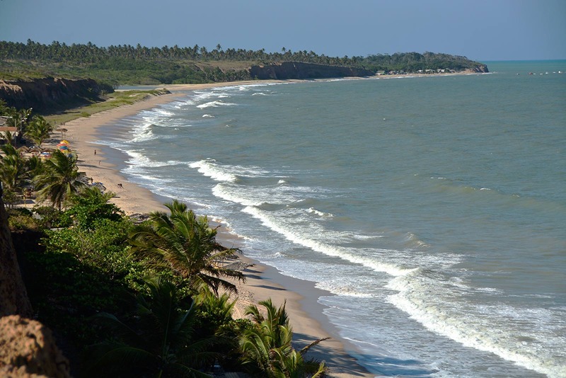 Praia do Sol deslumbrante com ondas e palmeiras em João Pessoa.
