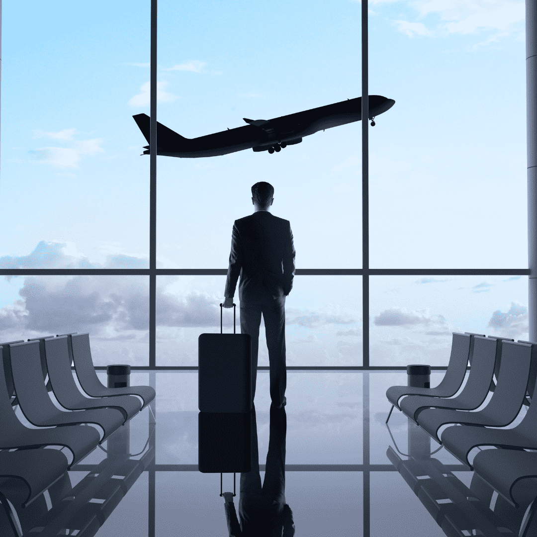 Homem com mala observa avião decolar em aeroporto, simbolizando o início de uma viagem