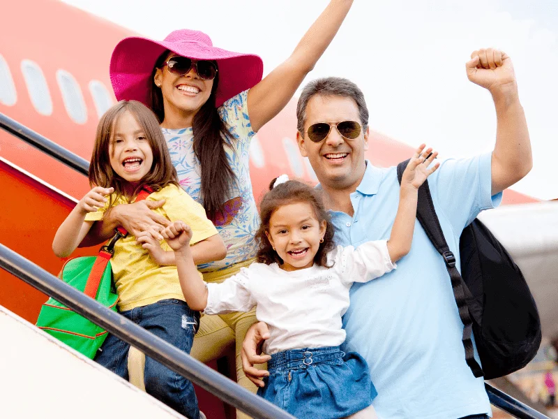 Família sorridente com crianças a bordo de um avião, começando suas férias em família com entusiasmo